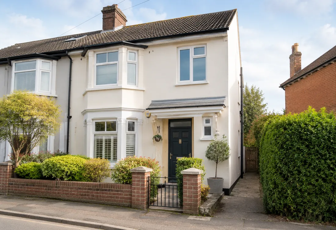 A well-maintained semi-detached UK house with a tidy front garden on a quiet street